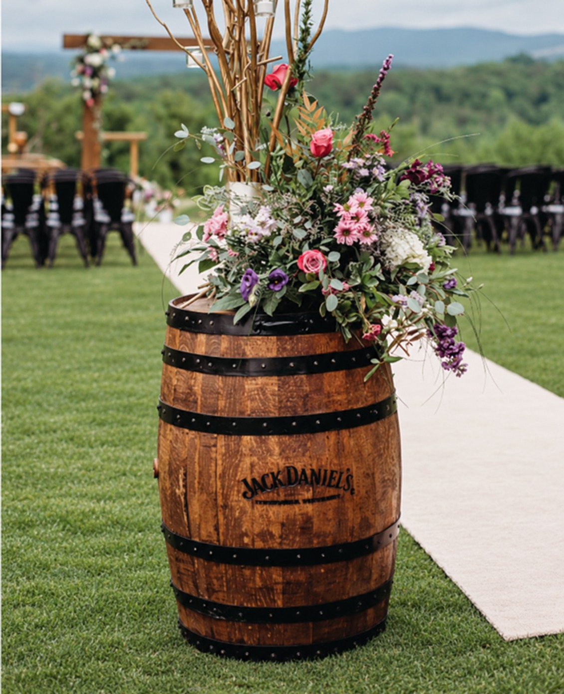 Floral barrel arrangement beside the wedding aisle at Garland Mountain